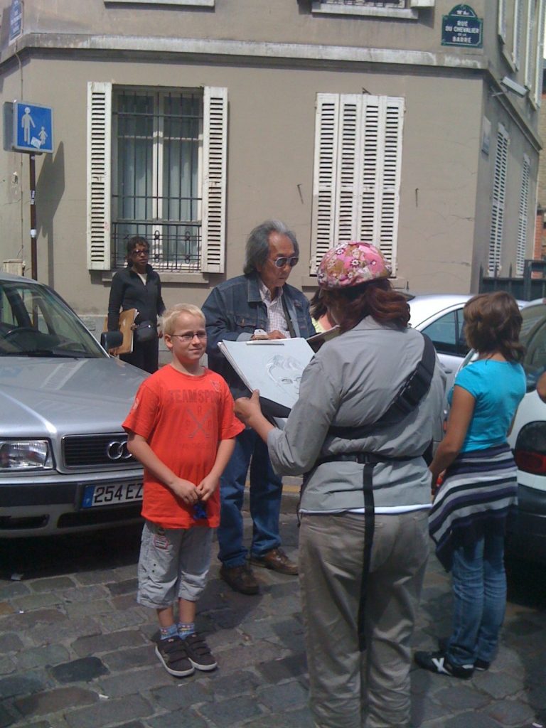 boy being sketched by street artist