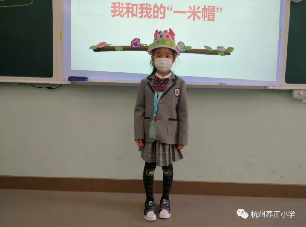 chinese school child wearing her social distancing hat